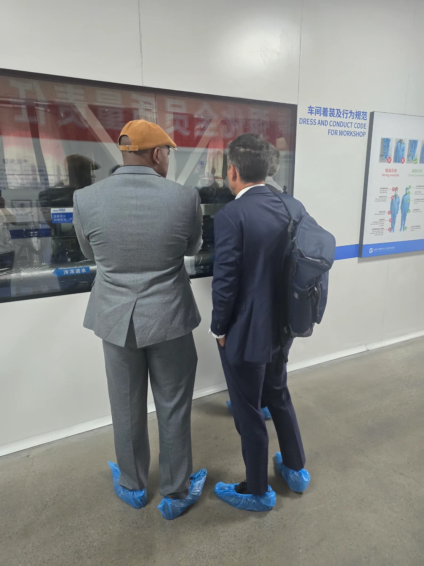 Partners discussing an energy storage system display at an industry exhibition.
